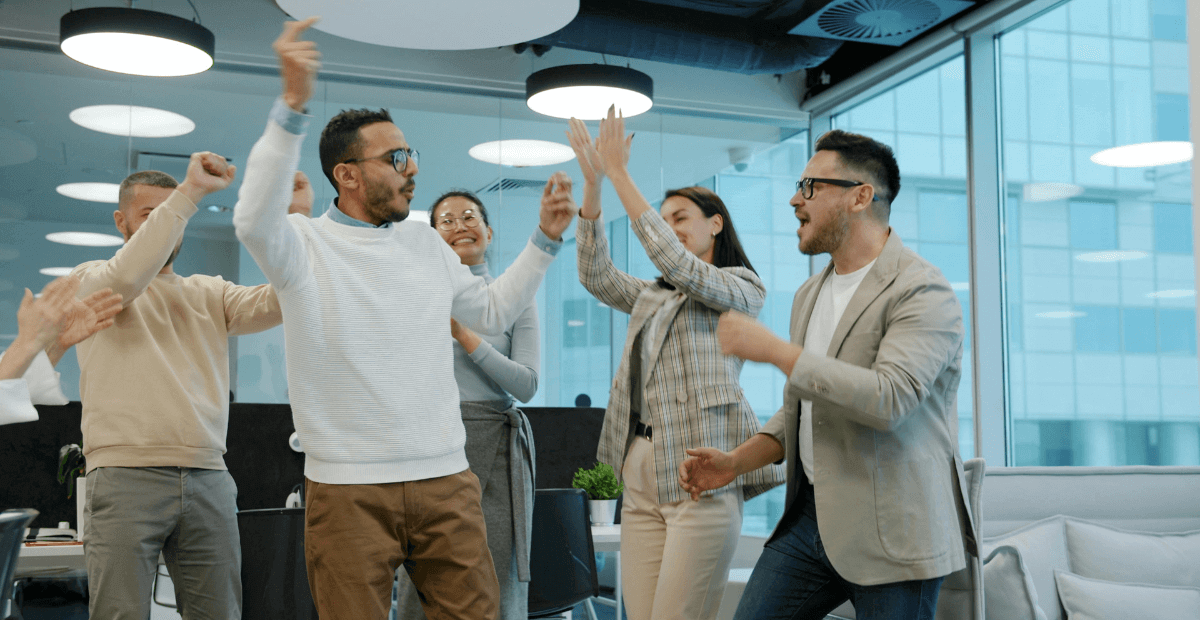 four people celebrating improved productivity thanks to mental health and wellbeing counselling